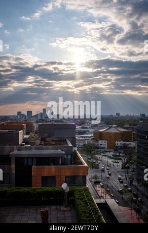 Evening sun rays shining through the clouds over Potsdamer Platz, Berlin, Germany in April 2019. Stock Photo