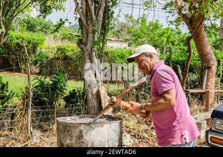 Man Using Pickaxe To Punch Hole In Drum Stock Photo