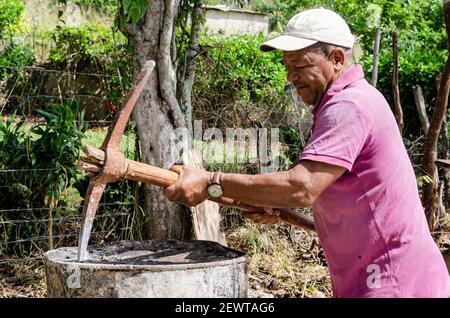 Man Using Pickax To Punch Holes In Drum Stock Photo
