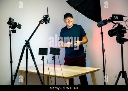 An influencer with a lens creating and recording content in his studio Stock Photo