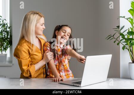 Helpful mother explaining to daughter about using a laptop Stock Photo