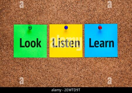 Three colored notes on cork board with words Look, Listen, Learn. Stock Photo