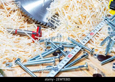 Carpenter tools on wooden table with sawdust. Circular Saw. Stock Photo
