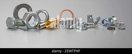 Different types of metal bolts, nuts, screws, hooks and washers. Fasteners and hardware tools on table. Stock Photo