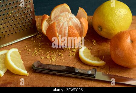 Tangerine fruit and slices lemon on a wooden board, shallow depth of field Stock Photo