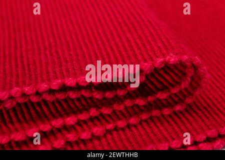 Bright red textured fabric. Red textile background. Ribbed folded fabric. Stock Photo