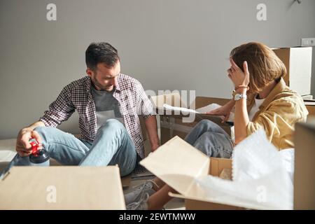 Couple searching for something among open cardboard boxes Stock Photo