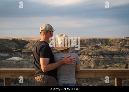 Active senior couple looking at view at Horseshoe Canyon near Drumheller in Alberta, Canada. Stock Photo