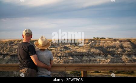 Active senior couple looking at view at Horseshoe Canyon near Drumheller in Alberta, Canada. Stock Photo