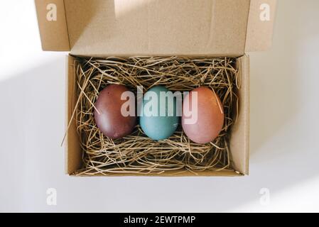 Colored eggs on straw in a box Stock Photo