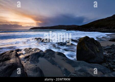 The sun sets over Ireland's Mizen Head peninsula, as seen from Barleycove beach near Crookhaven in West Cork on the Wild Atlantic Way. Stock Photo