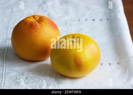 Ripe grapefruits on a white screwed tablecloth. Stock Photo