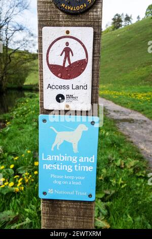 National Trust sign 'please keep your dog on a lead during nesting  time and lambing time', Wolfescote Dale, Milldale, Derbyshire, England, UK Stock Photo