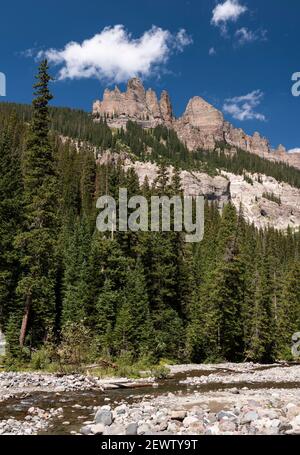 West Fork of The Cimarron River in Mid Summer.  Pinnacle rock formations on the Cimarron Ridge add to the beauty of this southwestern Colorado Valley. Stock Photo