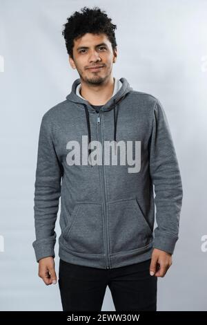 Hispanic man gray sweatshirt mockup front side - portrait of young hispanic man smiling on white background Stock Photo