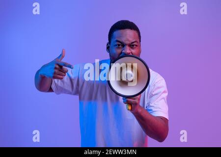 Agressive Black Guy Shouting Into Loudspeaker, Making Announcement And Emotionally Gesturing Stock Photo