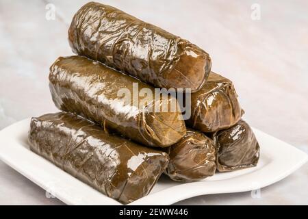 stuffed grape leaves with olive oil on white plate on the table Stock Photo