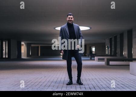 Handsome young businessman standing smiling. Stock Photo