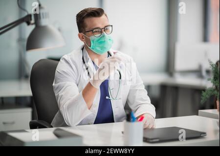 The attractive head of the medical department in his clinic shows the vaccine, received in the medical institution Stock Photo