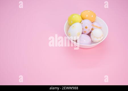Colored Easter eggs with different ornaments isolated in the pink background with copy space on the left Stock Photo