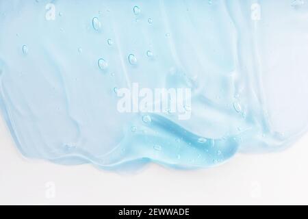 Clear skincare product smudge closeup. Cream gel blue transparent cosmetic sample with bubbles isolated on white background. Hand sanitizer, hygiene Stock Photo