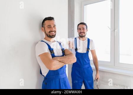 Two builders in overalls look at the camera Stock Photo