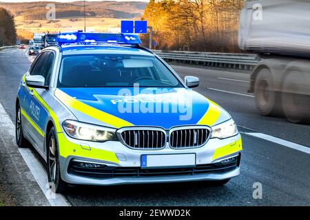 Police vehicle with blue lights in action on a motorway in Germany Stock Photo