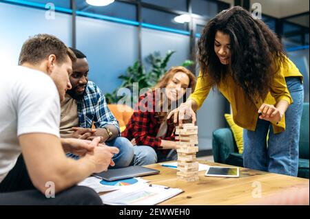 Happy friendly business people playing in office, taking a break. Joyful multiethnic coworkers having fun, resting from tense brainstorm, distracted from work or study Stock Photo
