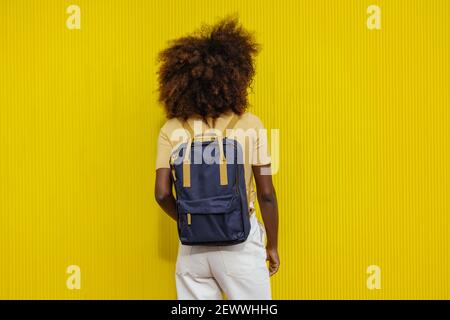 Back view black Woman with afro hair with a backpack on her back Stock Photo
