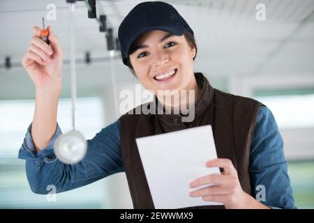 female worker screwing something in the ceiling Stock Photo - Alamy
