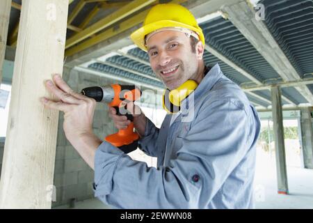 happy builder is holding a drill Stock Photo