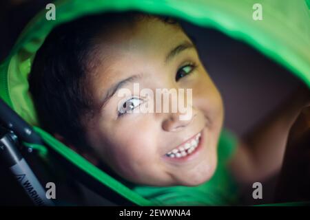 Boy looking through a green stroller