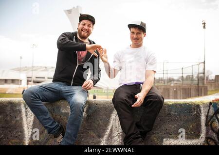 Two buddies bmxing and giving eachother a handshake