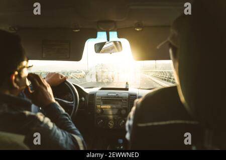 Two engineers inside a car going to work in the sunrise Stock Photo