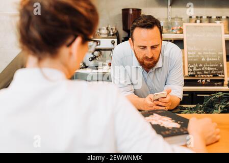 Restaurant lifestyle. Male chef using his phone leaning on bar counter Stock Photo