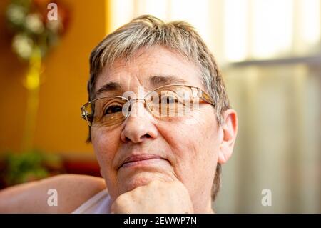 Close up portrait of face of senior woman wearing glasses and waiting Stock Photo