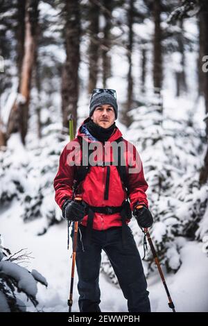 portrait of male skier with red jacket in snow covered woods in Maine Stock Photo
