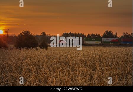 An early morning freight train passing through a farming community in northern Wisconsin. Stock Photo