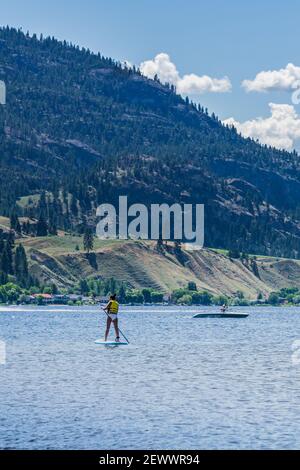 PENTICTON, CANADA - JULY 5, 2020: recreation time paddle boarding on scenic peaceful mountain lake Stock Photo