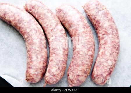 raw sausage links prior to cooking in a cast iron pan