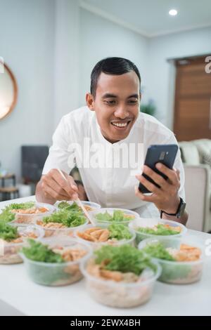 portrait of male home catering service preparing lunch box for takeaway food online order Stock Photo