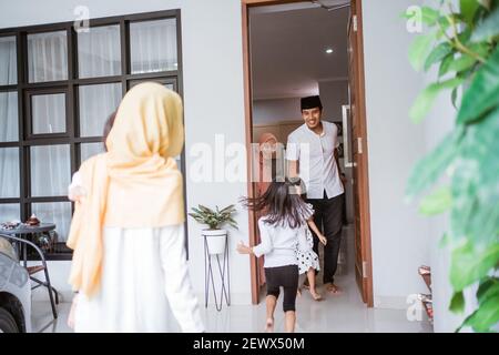 excited asian muslim family visiting friend during eid fitri mubarak at home Stock Photo