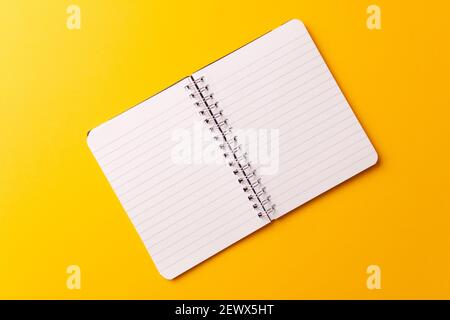A top view of an open journal isolated on a yellow background Stock Photo