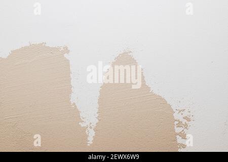 White beige cement texture stone concrete,rock plastered stucco wall. painted flat fade pastel background.decorative relief plaster on wall closeup Stock Photo