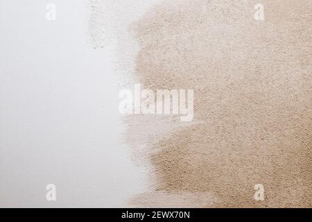 White beige cement texture stone concrete,rock plastered stucco wall. painted flat fade pastel background.decorative relief plaster on wall closeup Stock Photo