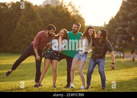 Happy student friends spending time together outdoors. Young hipsters having great time in countryside Stock Photo