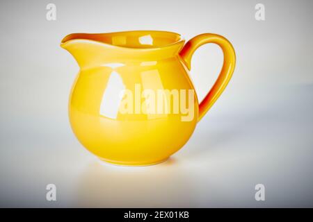 Small Yellow Ceramic Pitcher Jug on isolated white background Stock Photo
