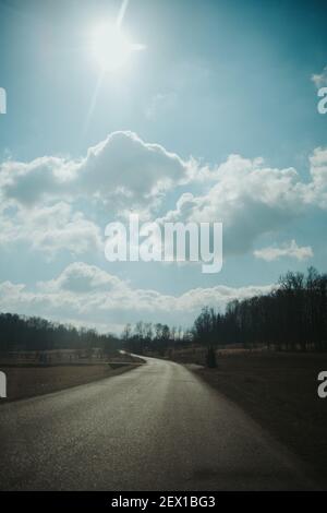 Country road over blue sky background Stock Photo - Alamy