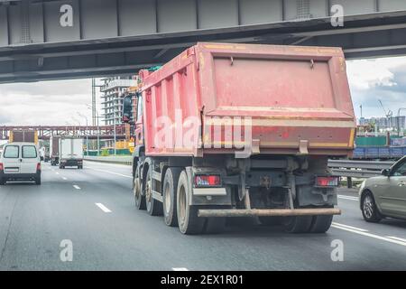 big dump truck goes in the evening on highway Stock Photo
