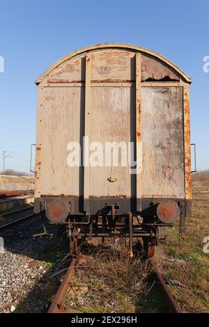 Old abandoned weathered and rusty train cargo wagon on an old train tracks Stock Photo